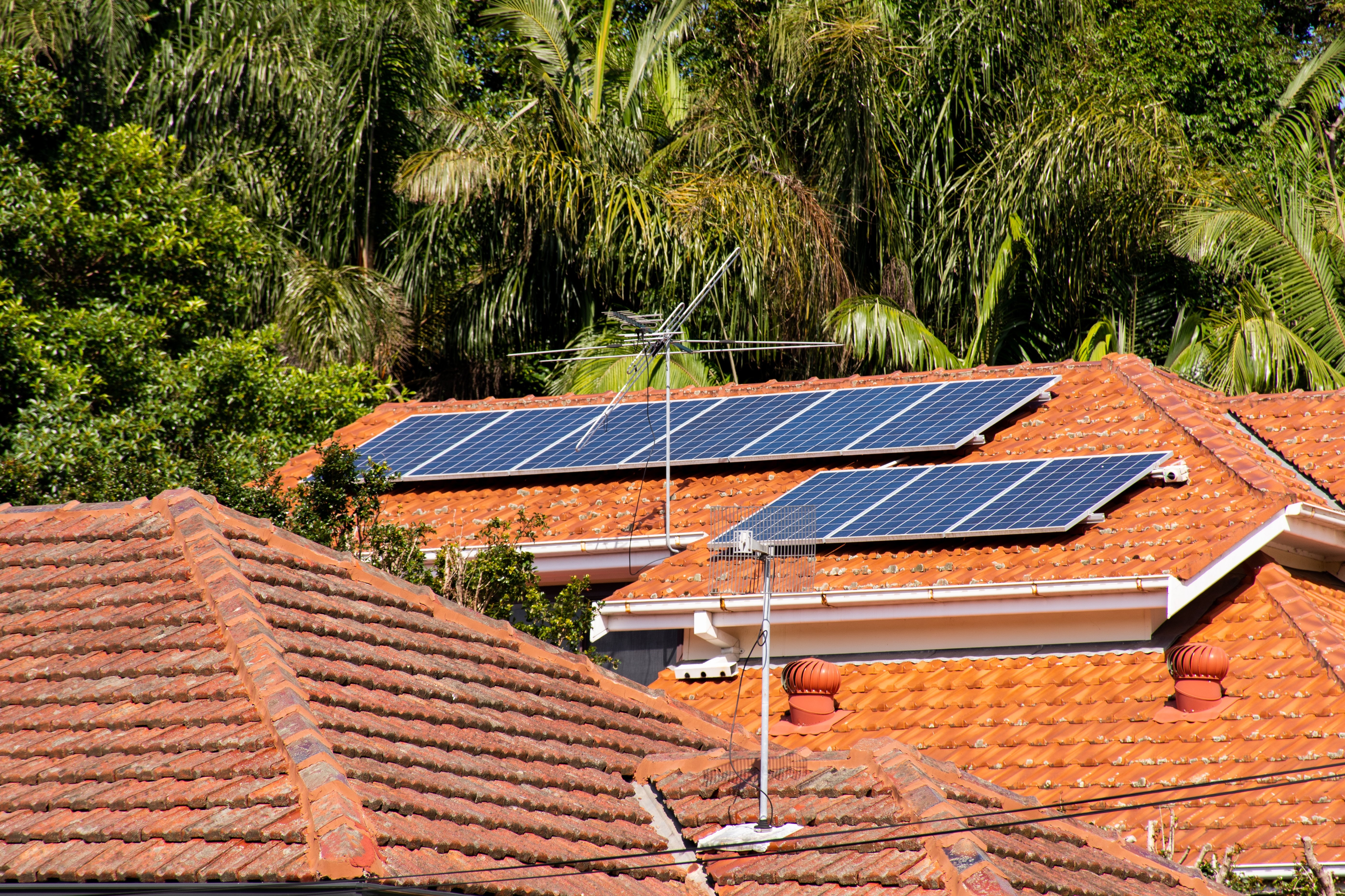 5 perguntas sobre energia solar. A imagem apresenta painéis solares instalados no telhado de um imóvel em um conjunto de casas
