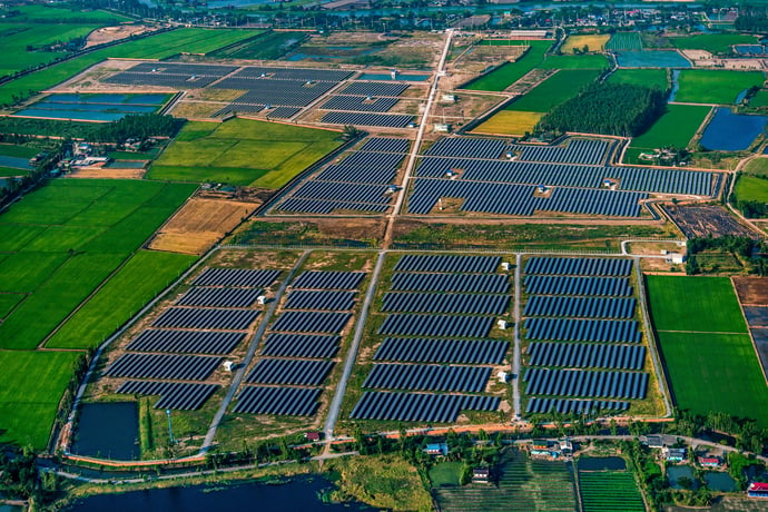 visão panorâmica ilustra o que é geração compartilhada de energia com enormes fazendas solares, repletas de painéis solares